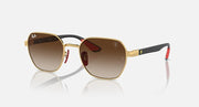 Sunglasses with gold frame and brown gradient lenses, black temples with red accent tips.