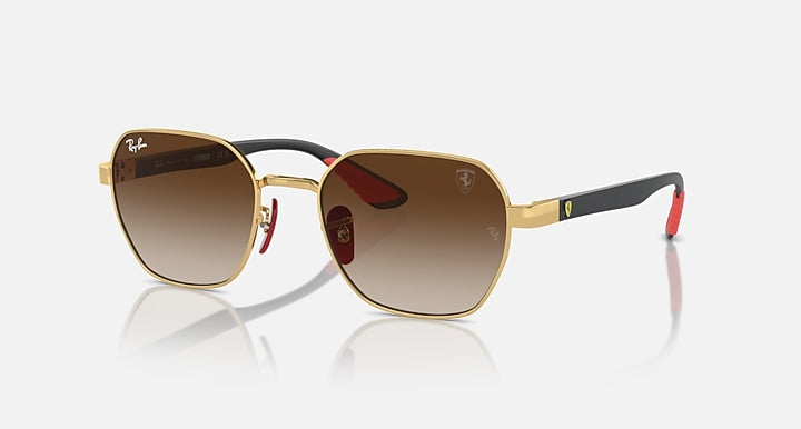 Sunglasses with gold frame and brown gradient lenses, black temples with red accent tips.