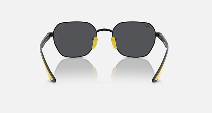 Black sunglasses with dark lenses and yellow inner frame accents, round shape
