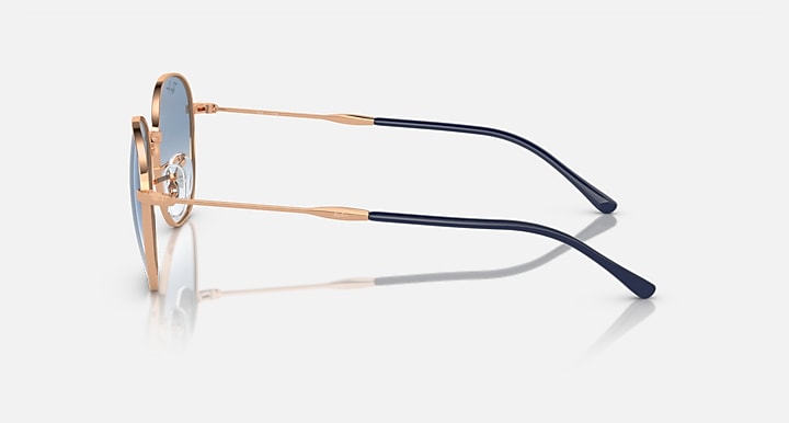Sunglasses side view with rose-gold frame and dark navy patterned temples.