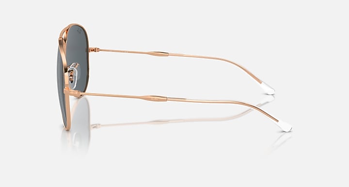 Aviator sunglasses with gold frame, dark lens, and clear tips on metal temples