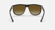 Sunglasses front view with dark frame and gradient amber lenses, metal hinges.