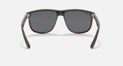 Sunglasses front view with black frame, gray lenses, and red trim details.