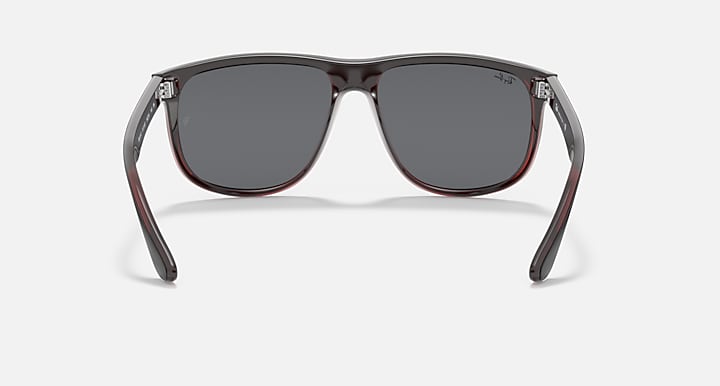 Sunglasses front view with black frame, gray lenses, and red trim details.