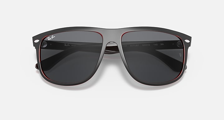 Sunglasses front view with black frame, dark lenses, and red trim around edges.