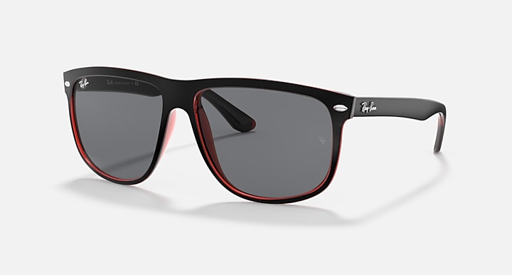Sunglasses with black frame, gray lenses, and red interior trim along rims.