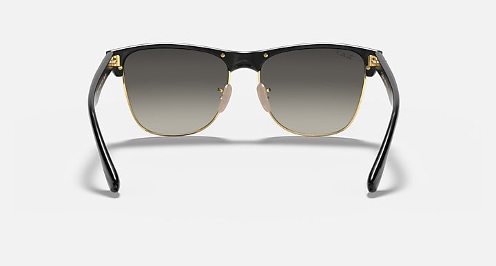 Oversized black browline sunglasses with dark lenses, gold-tone bridge and hinges