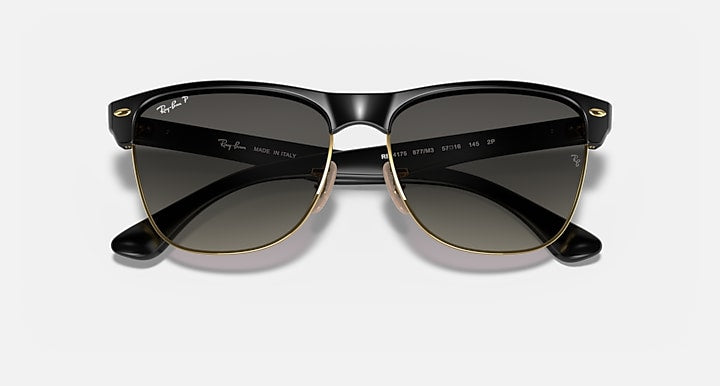 Oversized black sunglasses with dark lenses and gold-tone detailing, symmetrical front view