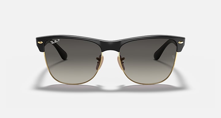 Oversized black browline sunglasses with dark lenses and gold-tone hinges, front view