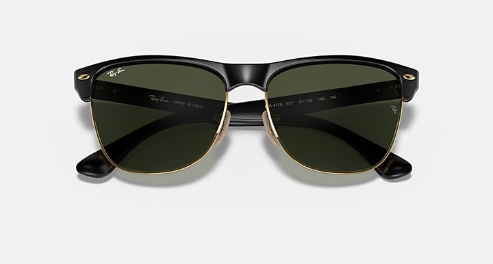 Oversized black sunglasses with green lenses and gold-tone detailing, symmetrical front view