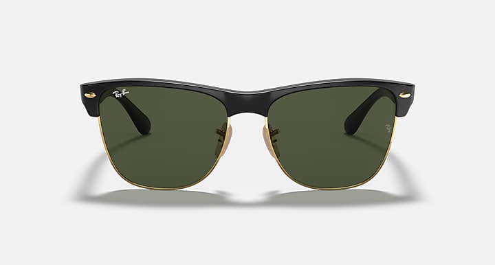 Oversized black browline sunglasses with green lenses and gold-tone hinges, front view