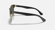 Black oversized sunglasses with green lenses and gold-tone temple tips, side profile