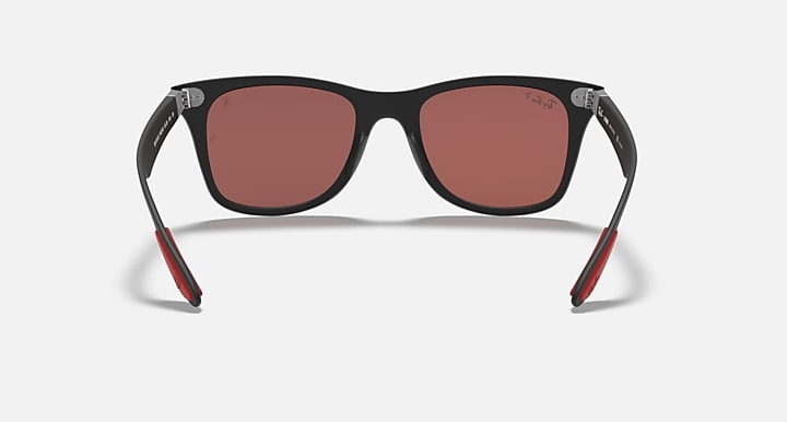 Black Ray-Ban sunglasses with pink lenses, temples showing red accents