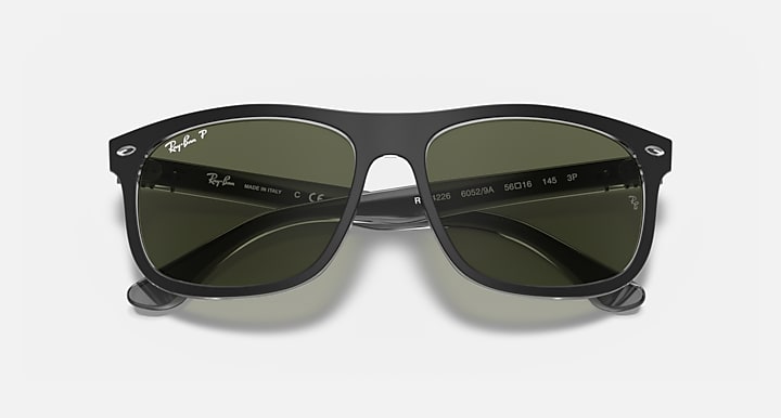 Black sunglasses with green lenses and Ray-Ban branding on the temple arms.