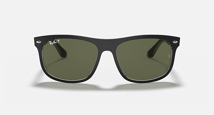 Black wayfarer sunglasses with green lenses and Ray-Ban logo on the temple.