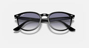 Black sunglasses with large round lenses and dark gradient tint, temple branding