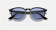 Black oversized round sunglasses with blue-tinted lenses and curved side arms