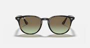 Sunglasses with dark tortoiseshell frames and round green gradient lenses