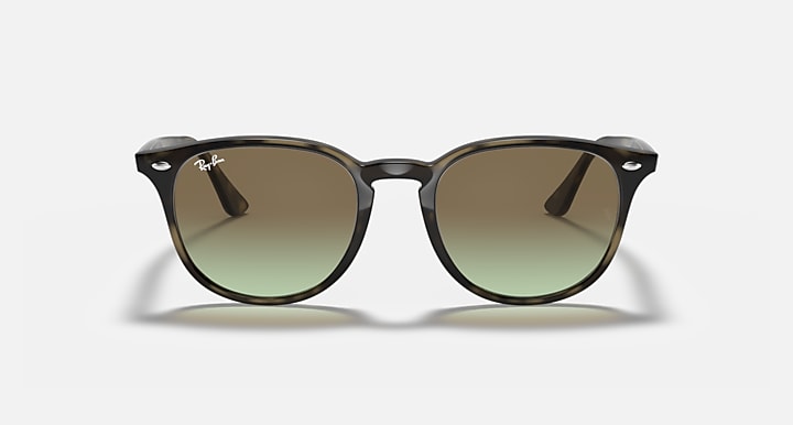 Sunglasses with dark tortoiseshell frames and round green gradient lenses