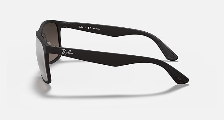 Matte black sunglasses with tinted lenses, side view, and Ray-Ban logo