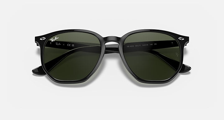 Ray-Ban hexagonal sunglasses with dark frames and green tinted lenses, angled front