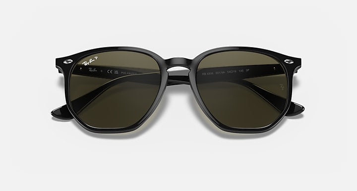 Black hexagonal sunglasses with dark green tinted lenses and curved temples