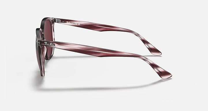 Hexagonal sunglasses side view with burgundy striped frame and dark maroon lenses