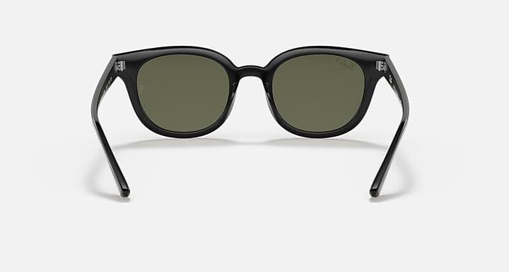 Front of round sunglasses with dark frames and green-tinted lenses