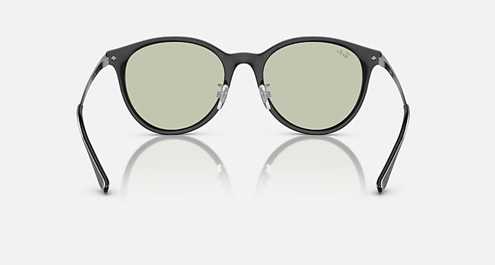 Dark round sunglasses with green-tinted lenses and curved temple arms