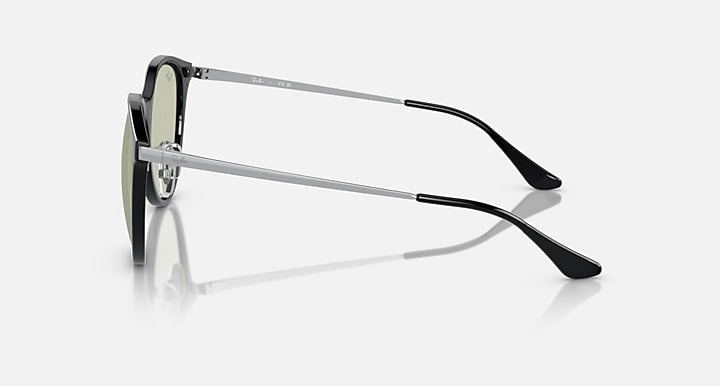 Sunglasses side profile with dark frame and green-tinted lens, silver metal temples