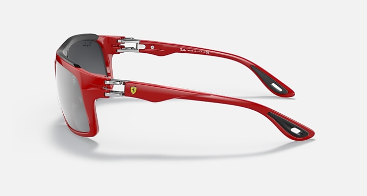 Red aviator sunglasses with silver hinges and dark gray lenses, side view