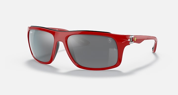 Red aviator-style sunglasses with dark gray lenses and clear side arms