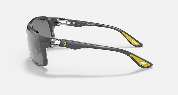 Dark gray aviator sunglasses with yellow accents and gray tinted lenses, side view