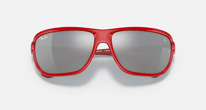 Red aviator sunglasses top view with dark gray lenses and brand-marked temple