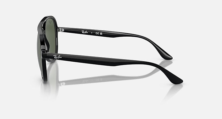 Sunglasses side view with dark arms and dark green lens rims, aviator style