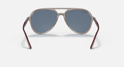 Ray-Ban aviator sunglasses with beige frame, maroon accents, and blue-tinted lenses.