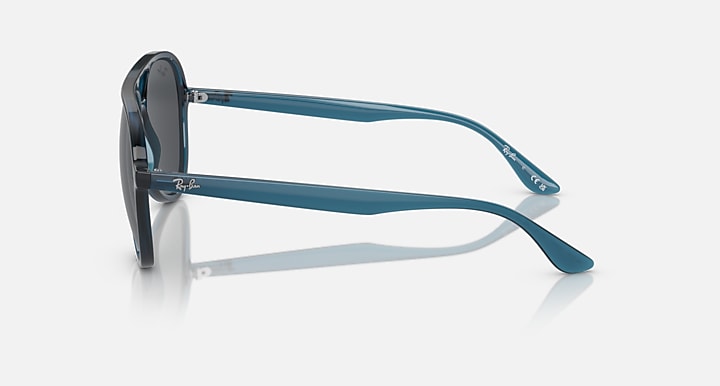 Ray-Ban aviator sunglasses with dark gray lenses, blue temple arms and side profile.