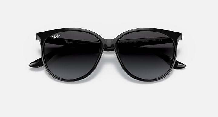 Black frame sunglasses with very dark lenses, rounded cat-eye profile