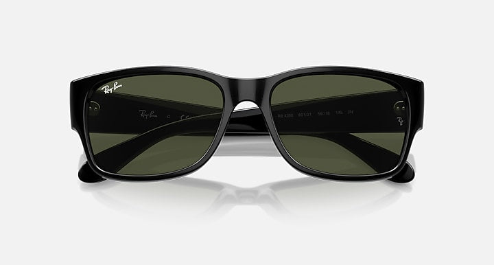 Black sunglasses with dark green lenses and subtle Ray-Ban markings on lens