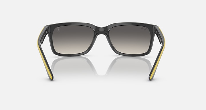 Ray-Ban RB4393M sunglasses, black frames with yellow side accents and grey gradient lenses