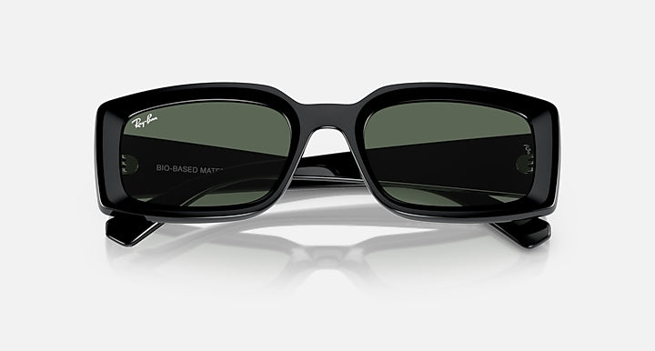 Black sunglasses with dark green lenses and thick wraparound frame