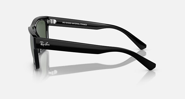Black sunglasses with dark green lenses and curved arms, side view