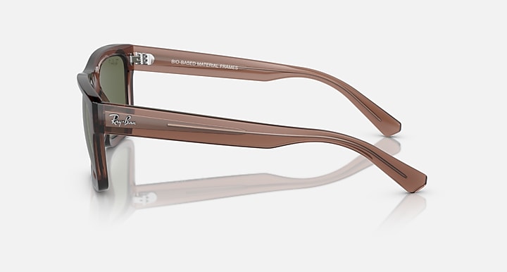 Transparent brown sunglasses with dark green lenses and curved arms, side view