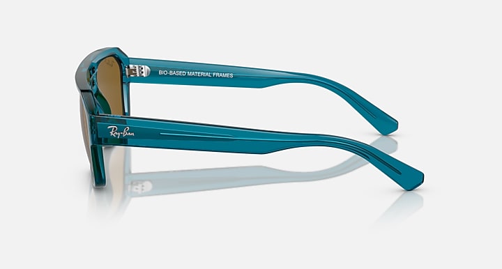 Blue-green sunglasses side view with branded temple and brown lens