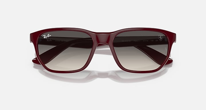 Ray-Ban RB4404M sunglasses, angled top view with dark red frames and grey lenses