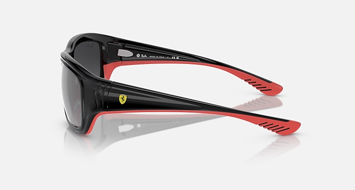 Black sunglasses with red rubber temples and dark mirrored lenses, side view