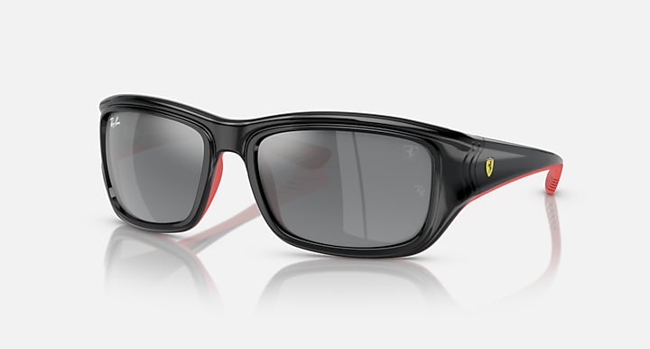 Black sunglasses with dark grey mirrored lenses and red rubber temple tips