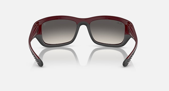 Dark red sunglasses with dark grey lenses and squared frame shape