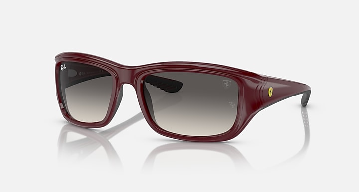 Dark red sunglasses with brownish-grey lenses and black temple accents