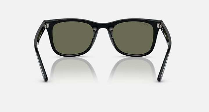 Black sunglasses with green-tinted lenses and front view, angled temples